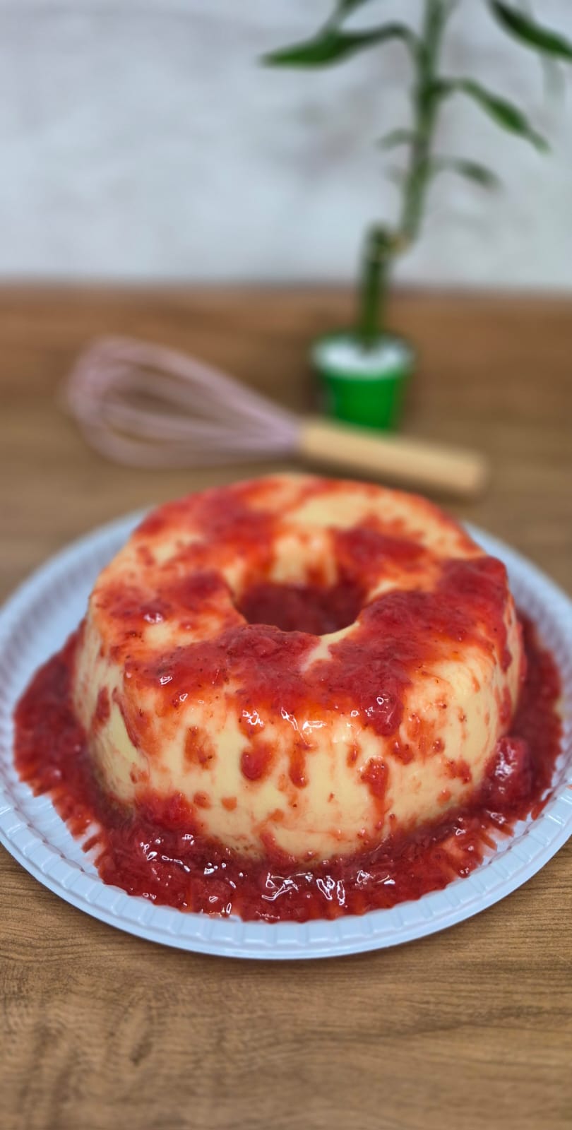 Pudim belga branco com calda de morango sobre prato branco