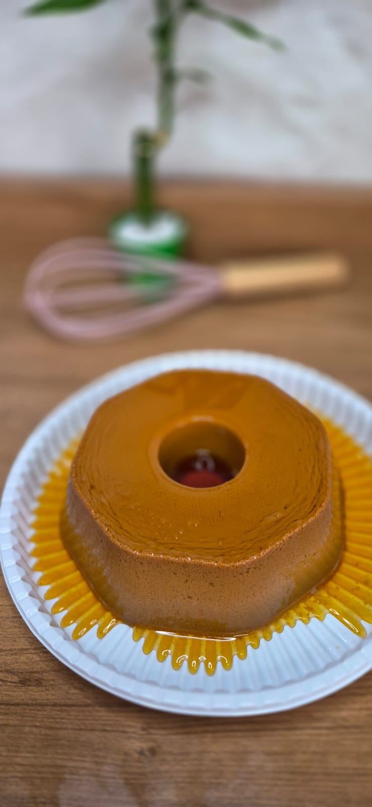Pudim de doce de leite com calda dourada sobre prato branco