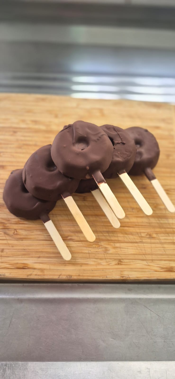 Picodins cobertos com chocolate sobre uma bancada de madeira